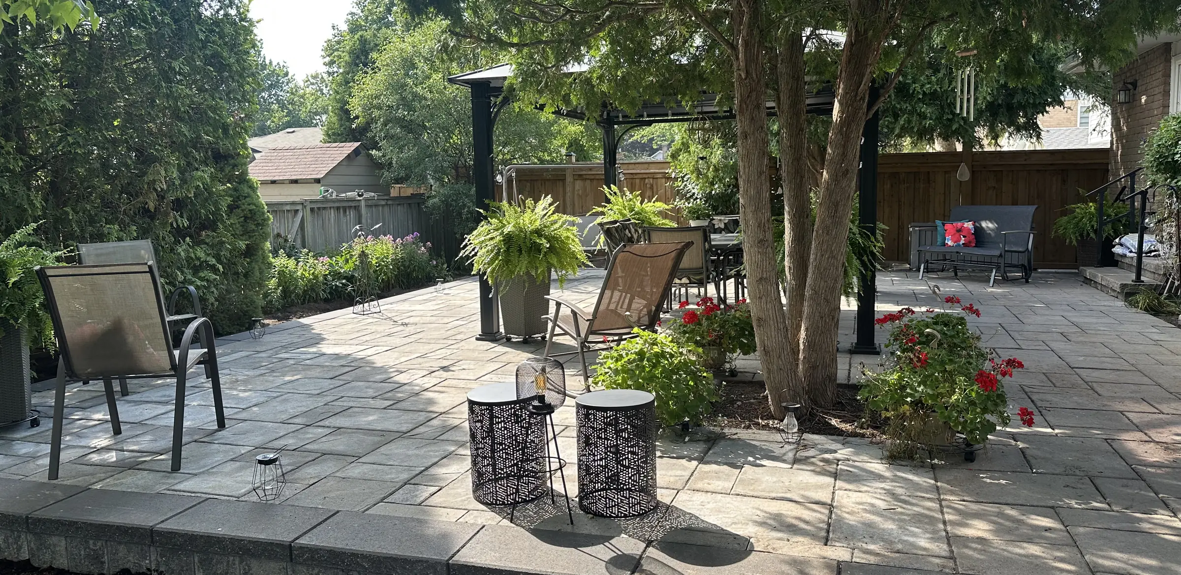 Interlock patio with planters and seating under mature trees