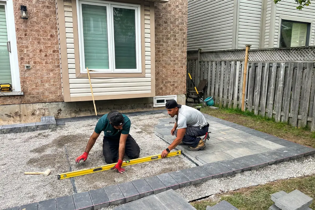 Two crew members levelling an interlock patio base