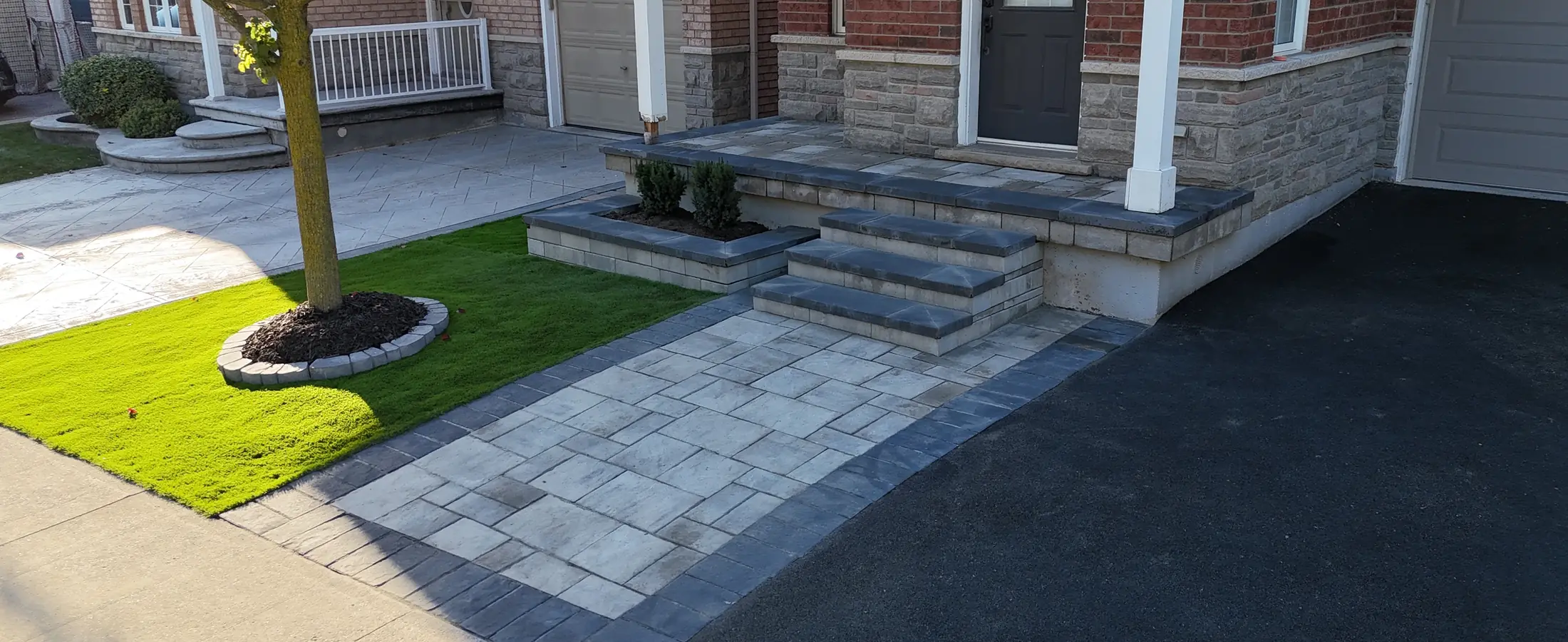 Interlock front steps and walkway beside an asphalt driveway